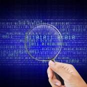 hand met vergrootglas en cijfercodes