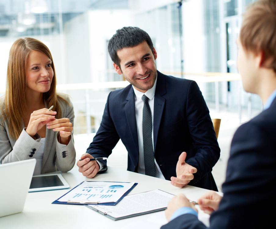 vrouw en 2 mannen overleggen aan een tafel