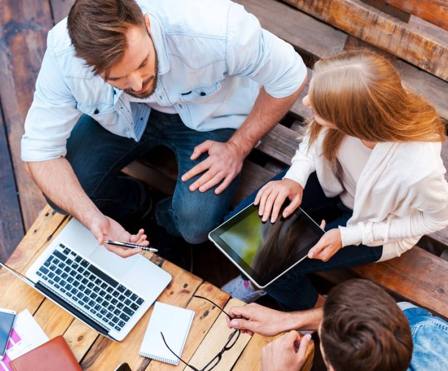 groepje vergadert buiten met laptop en tablet
